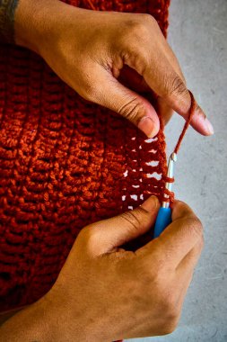 Yetenekli eller Fort Wayne, Indiana 'da paslı bir ipliği hayata döndürür. Bu yakın plan, tığ işi sanatını ve işteki Afrikalı Amerikalı bir zanaatkârın odak noktasını gösteriyor. Terfi için ideal