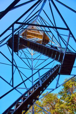 Hocking Hills, Ohio 'daki Ash Cave Fire Tower' ı araştır. Serüven yakalamak Bu çarpıcı düşük açılı görünüm ile açık mavi gökyüzü karşı, geometrik tasarımlar vurgulanıyor ve yemyeşil orman çevresi.