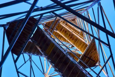 Hocking Hills, Ohio 'daki Ash Cave Fire Tower' da yükselen macera. Doğadaki bu mimari mucizeyi keşfederken, açık mavi gökyüzüne karşı metal ve ahşap karışımını yakalayın..