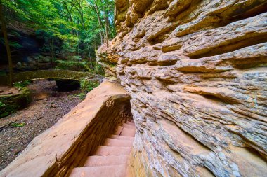 Hocking Hills, Ohio 'daki büyüleyici Old Mans Mağara Yolu' nu keşfedin. Taştan merdivenlerden in ve kır köprüsünü geç, yemyeşil ve kumtaşı oluşumlarıyla çevrili. Macera için mükemmel.