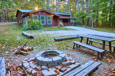 Experience autumn tranquility at a rustic cabin in Hocking Hills, Ohio. Surrounded by lush forest, enjoy outdoor gatherings around the firepit, perfect for a serene nature escape. clipart