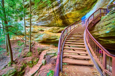 Ohio 'daki Hocking Hills Eyalet Parkı' nın büyüleyici güzelliğini keşfedin. Yeşillik ve dramatik kaya oluşumlarıyla çevrili Old Mans Mağara Yolu 'nun kırsal ahşap merdivenlerinde dolaşın. Macera bekliyor..