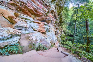 Explore the vibrant fall colors of Hocking Hills Ohio. This serene landscape captures Rock Houses layered cliffs and lush forest inviting adventure along a sunlit path through natures beauty. clipart