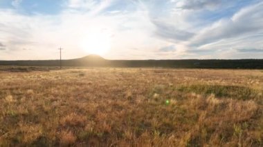 Havadan Uçarak İlerleyin: Utah, Kasırga 'daki Gooseberry Mesa' nın dingin güzelliğini tecrübe edin, altın otlar ılık bir günbatımının altında hafifçe sallanırken, barış ve keşfi çağrıştırıyor..