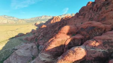 Havadan Uçarak İlerleme: Las Vegas yakınlarındaki Red Rock Kanyonunun nefes kesici güzelliğini tecrübe edin. Kırmızı kumtaşı oluşumlarına hayran kaldım. Açık mavi gökyüzüne karşı altın saat ışığı altında yıkandım..