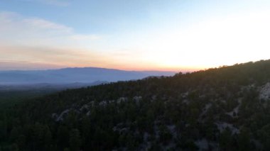 Charleston Nevada dağının üzerinde, hava yoluyla ilerleyen hava, verimli ormanları ve sisli tepeleri açığa çıkarıyor. Altın ışık ve uçsuz bucaksız manzara huzuru çağrıştırıyor ve keşif ve sükuneti davet ediyor..
