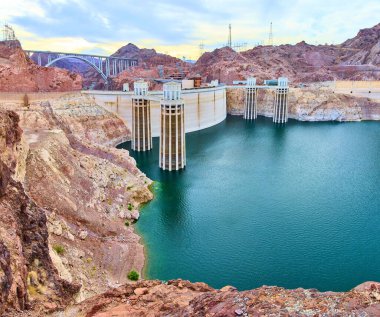 Boulder City yakınlarındaki Hoover Barajı 'ndaki doğa ve mühendisliğin nefes kesici füzyonuna tanık olun. Bu panoramik manzara ikonik barajı ve Meads Gölü 'nün sakin sularını yakalıyor, engebeli Nevada Çölü tarafından çerçevelenmiş..