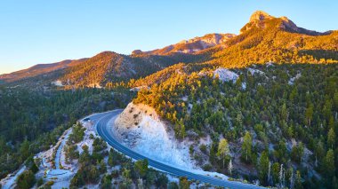 Nevada, Charleston Dağı 'nın havadan görünüşü: Altın saat ışığı, gür çam ormanları ve engebeli dağların arasından geçen dolambaçlı bir yolu yıkıyor, keşifleri teşvik ediyor ve macera ve huzurun özünü yakalıyor..