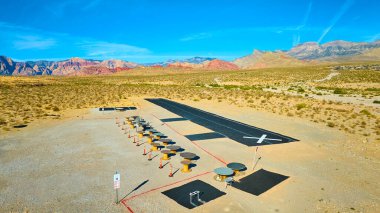 Nevada 'daki Mountain Springs' teki model bir uçak pistinin hava görüntüsü. Kızıl Kaya Kanyonu yakınlarında geniş bir çöl manzarasıyla çevrelenmiş bu görüntü kurak arazinin sükunetini ve izolasyonunu yakalar..