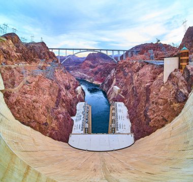 A breathtaking view of the iconic Hoover Dam and Colorado River from above. The Mike OCallaghan Pat Tillman Memorial Bridge adds to the grandeur, illustrating human innovation amidst nature. clipart