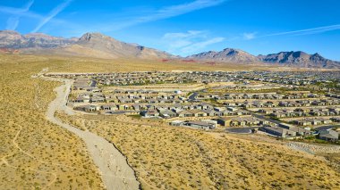 Mountain Springs Nevada 'daki bir banliyö yerleşim alanının havadan görünüşü. Engebeli Kızıl Kaya Kanyonu 'na uzanan bu sahne, doğayla uyum içinde bir çöl manzarası sergiliyor.