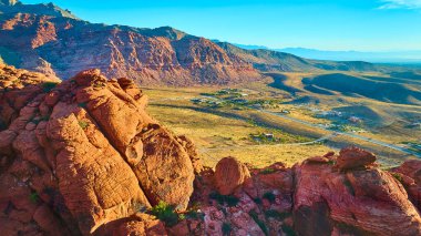 Nevada 'daki Kızıl Kaya Kanyonu' nun altın saat içindeki havadan görünüşü, canlı kırmızı kumtaşı oluşumları ve geniş çöl manzaraları sersemletici bir doğa harikası yaratıyor, macera ve seyahat teması için mükemmel..