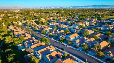 Las Vegas 'ın sakin bir banliyösünün havadan görünüşü terakotta çatılı evleri ve ikonik ufuk çizgisi ve çöle karşı kurulmuş palmiye çizgili caddeleri. Gayrimenkul veya şehir yaşam tarzı içeriği için mükemmel.