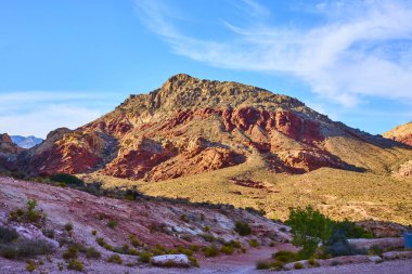 Çarpıcı kaya oluşumlarının açık mavi gökyüzü ile buluştuğu, Nevada, Red Rock Canyon 'un canlı renklerinin tadını çıkarın. Macera ve doğa keşfi için mükemmel bir zemin..