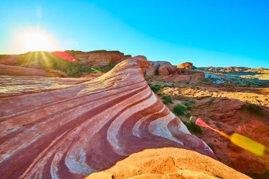 Fire State Park Vadisi 'nde nefes kesici Ateş Dalgası kaya oluşumunu tecrübe edin. Güneşin doğuşu kırmızı ve beyaz katmanların üzerine altın bir ışık saçıyor ve Nevada 'da büyüleyici bir çöl manzarası yaratıyor..