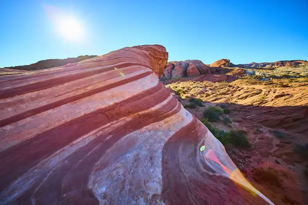 Nevada 'daki Fire State Park Vadisi' nde canlı Ateş Dalgası kaya oluşumu üzerinde gün doğumu. Sersemletici kırmızı, pembe ve beyaz kumtaşı kıvrımları açık mavi gökyüzüne karşı büyüleyici bir doğal görüntü yaratır..