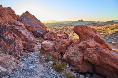 Nevada Moapa Vadisi 'ndeki Ateş Vadisi Parkı' nın nefes kesici kızıl kaya oluşumlarını araştırın. Altın saat boyunca çöl manzarasının canlı renklerini ve altın parıltısını hissedin..