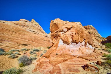 Nevada Moapa Vadisi 'ndeki Ateş Vadisi' nin nefes kesici güzelliğini keşfedin. Yükselen kızıl kaya oluşumları, canlı renkleri ve derin mavi gökyüzünün altındaki sakin çöl manzarasıyla..