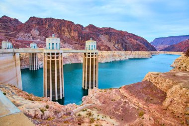 Colorado Nehri üzerinde yükselen Hoover Barajı, insani yenilik ve doğal güzelliğin bir karışımını sergiliyor. Öğleden sonra ışığı Nevada çölündeki su yönetimi ve enerji alanındaki rolünü vurguluyor..