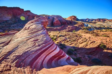 Nevada 'daki Fire State Park Vadisi' ndeki nefes kesici Ateş Dalgası 'nı keşfedin. Parlak bir çöl gökyüzünün altında canlı kırmızı, pembe ve beyaz kumtaşı katmanları, macera için mükemmel bir sahne ve