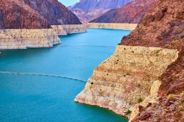 Mead Gölü 'nün çarpıcı mavi suları, berrak gökyüzünün altındaki yüksek uçurumlarla çevrili görkemli manzarası. Hoover Barajı ve Boulder City yakınlarında Arizona ve Nevada arasındaki dingin güzelliği yakalayın..