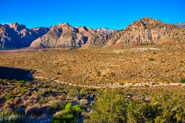 Nevada 'daki Red Rock Kanyonu' nun nefes kesici manzarası. Engin mavi gökyüzünün altındaki engebeli kumtaşı zirveleri engin çöl manzarasında maceralı bir keşif için çarpıcı bir zemin oluşturur..