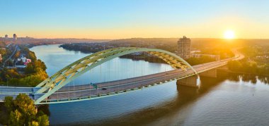Cincinnati Daniel Carter Sakal Köprüsü 'nde altın saat. Kemer, sakin Ohio Nehri 'ni gererek canlı şehri doğaya bağlıyor. Seyahat, altyapı ve sükunet temaları için ideal.