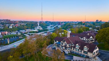 Cincinnati 'nin gün batımında büyüleyici bir hava manzarası. Bereketli yeşilliğin ortasında, Tudor tarzı büyüleyici bir bina. Kenar mahalle yaşamının sakinliğiyle kentsel gelişimin sorunsuz bir şekilde harmanlanmasını tecrübe edin..