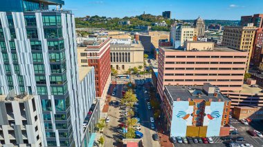 Modern ve tarihi mimarinin sergilendiği Cincinnati şehir merkezinin havadan görünüşü. Gösterişli gökdelen ve yemyeşil tepelerin yakınındaki sanatsal duvar resmi ve Hamilton County