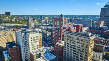 Cincinnati şehir merkezinin hava görüntüsünde Hamilton Adliyesi, açık mavi gökyüzü altında yemyeşil manzaralara doğru giden otobanlar ile tarihi ve modern mimari bir karışımın ortasında sergileniyor..