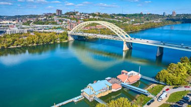 Aerial view of Cincinnati Daniel Carter Beard Bridge spanning the Ohio River. The vibrant cityscape blends urban life with nature, showcasing a harmonious balance between architecture and greenery. clipart