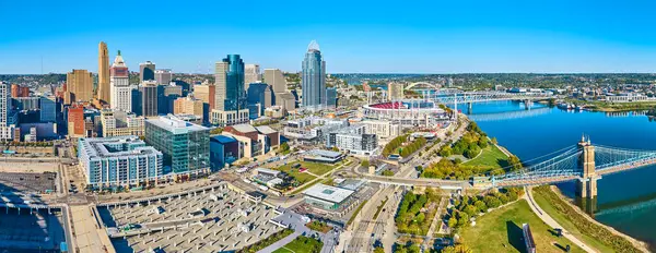 Ohio Nehri üzerindeki ikonik Roebling Askı Köprüsü ile Cincinnati 'nin canlı ufuk çizgisinin havadan görüntüsü. Bu dinamik şehir manzarasında şehir hayatının ve mimari güzelliğin özünü yakalayın..