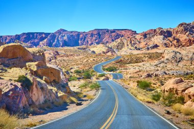 Nevada 'nın manzaralı Moapa Vadisi' nde bir maceraya atılın. Dolambaçlı bir çöl yolu sizi açık mavi gökyüzü altında nefes kesen kırmızı kaya oluşumlarına götürür ve keşfin ruhunu yakalar..