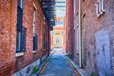 Sonbahar yapraklarının dağıldığı, tuğla binaların yükseldiği Cincinnati kentsel geçidinin gizli cazibesini keşfedin. Ve tarihi bir simge, uzaktaki süslü cephesi ve kemerli pencereleriyle sizi çağırıyor..