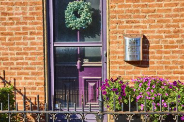 Çiçekli ve petunyalı büyüleyici mor kapı Cincinnati 'de kırmızı tuğlalı cephede çiçek açıyor. Zarif bir posta kutusu bu rahat ortama modern bir dokunuş katıyor. Emlak temaları için mükemmel..