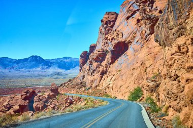 Nevada 'daki Moapa Vadisi Ateş Vadisi' nin saf güzelliğini keşfedin. Kızıl kaya oluşumları ve dolambaçlı bir yol bu nefes kesici çöl manzarasında macera ve özgürlük vaat ediyor. Seyahat için ideal