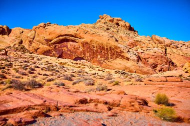 Bask in the breathtaking beauty of Moapa Valley Valley of Fire. Discover rugged red rock formations under a brilliant blue sky, embodying the raw allure of the American Southwest desert landscape. clipart