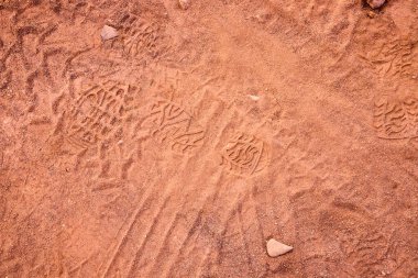 Ayak izleri Utah 'taki Gooseberry Mesa' da tozlu bir patikada çaprazlamasına geçiyor, macera ve keşfin özünü dokulu kırmızı toprak ve parlak öğle güneşinin altında dağınık çakıl taşlarıyla yakalıyor..
