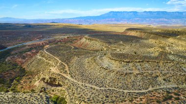 Gooseberry Mesa 'nın hava manzarası, Utah Kasırgası. Uçurumları ve kayalıkları olan engebeli çöl manzaraları, dolambaçlı toprak patikalar ve berrak bir gökyüzünün altındaki uzak dağlar. Macera ve keşif için mükemmel.