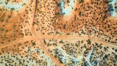 Utah 'taki Gooseberry Mesa' nın havadan görünüşü çöl manzarasının engebeli güzelliğini gözler önüne seriyor. Toprak bir yol seyrek bitki örtüsünü keser, açık mavi altında ham ve el değmemiş cazibeyi ön plana çıkarır.