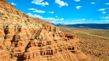 Utah Kasırgası 'ndaki Gooseberry Mesa' nın hava görüntüsü açık mavi gökyüzü altında görkemli kırmızı kaya oluşumlarını ortaya çıkarıyor. Amerika 'nın güneybatısının engebeli güzelliğini ve macerasını sergilemek için mükemmel..