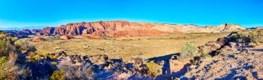 Witness the stunning panorama of Snow Canyon State Park in Utah. Majestic red rock formations meet a clear blue sky, offering a breathtaking desert landscape perfect for adventure and exploration. clipart