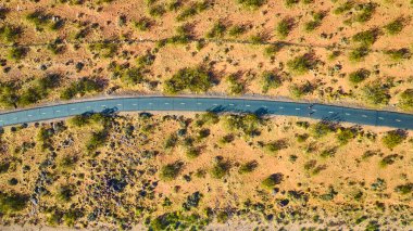 Utah 'taki Kar Kanyonu Eyalet Parkı' nda dolambaçlı bir yol. Altın saat sırasında ele geçirildi. Havadan bakıldığında, doğa ile insan gayreti arasındaki sakin macera ve zıtlığın altı çiziliyor.