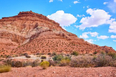Utah Çölü 'ndeki Bektaşi üzümü Mesa' sının huzur veren güzelliğini görün. Açık mavi bir gökyüzü altında, doğanın esansını yakalayan çarpıcı tortul kaya oluşumlarına hayret ediyorum..