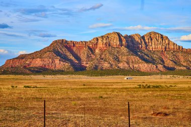 Altın saat ışığı, Utah, Bektaşi üzümü Mesa 'yı yıkıyor ve engebeli kırmızı kaya oluşumlarını vurguluyor. Uçsuz bucaksız çöl ve ıssız kulübe yalnızlığı ve Amerika 'nın ebedi güzelliğini çağrıştırıyor..
