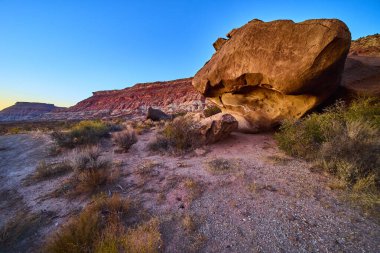 Utah 'ın güneybatı çölündeki Bektaşi üzümü Mesa' sının nefes kesici manzarası. İkonik kırmızı kayalar, yıpranmış kayalar ve dingin bir doğal güzellik yaratan altın saat ışığı ile sonsuz yalnızlık deneyimi..
