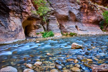 Utah, Zion Ulusal Parkı 'ndaki Narrows' un dingin güzelliğini keşfedin. Yükselen kırmızı kaya duvarları, canlı yapraklar ve temiz akan nehir, bir sonraki açık hava maceranız için mükemmel..