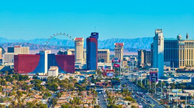 Parlak Las Vegas siluetinin gökyüzü manzarası ikonik yüksek tekerlekli dönme dolap Rio ve Palms gibi hareketli kumarhaneler berrak mavi gökyüzünün altında sersemletici çöl dağlarına çarpıyor..