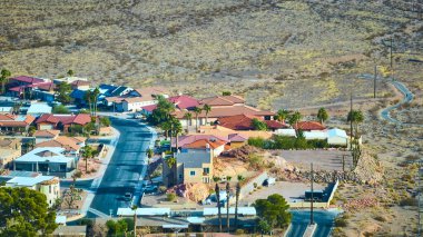 Aerial view of a modern suburban neighborhood in Boulder City, Nevada. Red-tiled roofs contrast sharply with the surrounding arid desert landscape, capturing the harmony of living amidst nature. clipart