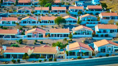 Discover the charm of desert living in Boulder City, Nevada. Aerial view of a harmonious suburban neighborhood with terracotta-roofed homes nestled amidst a serene desert landscape. clipart